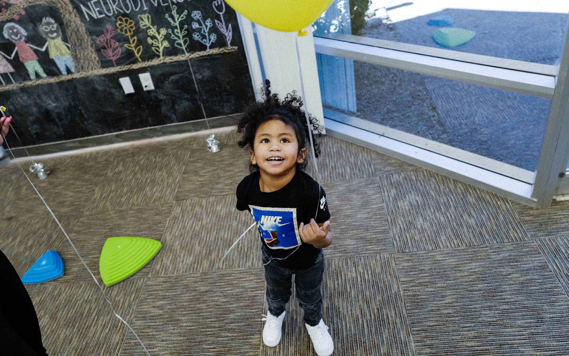 Enjoying a balloon, a kiddo experiences interactive play at InBloom's Learning Centers.