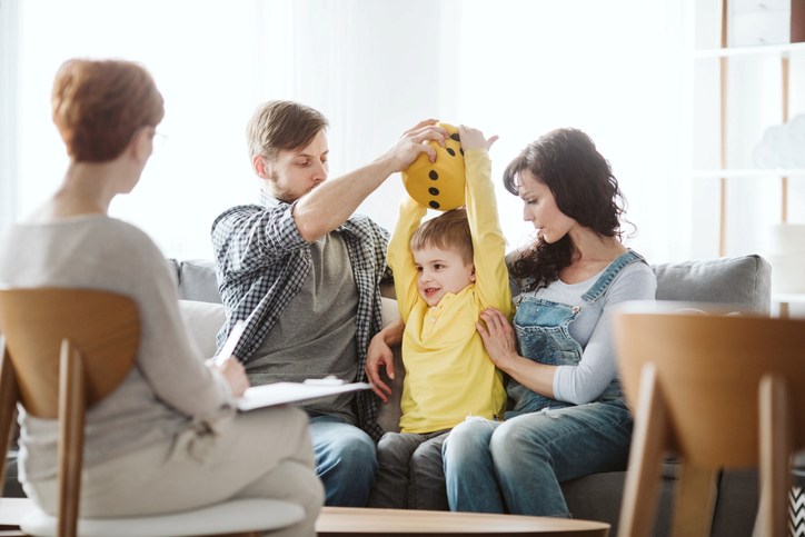 Family Supporting Child During Play-Based Therapy Session with Clinician