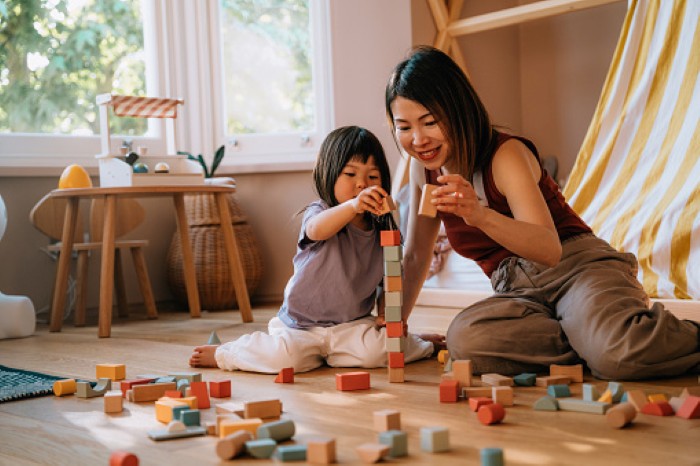 Mother and Daughter Playing Together with Colorful Building Toy Blocks