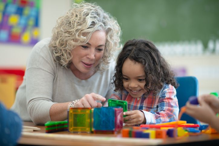 The Teacher and Her Student Are Building a Cube Together Out of Magnetic Plastic Building Pieces
