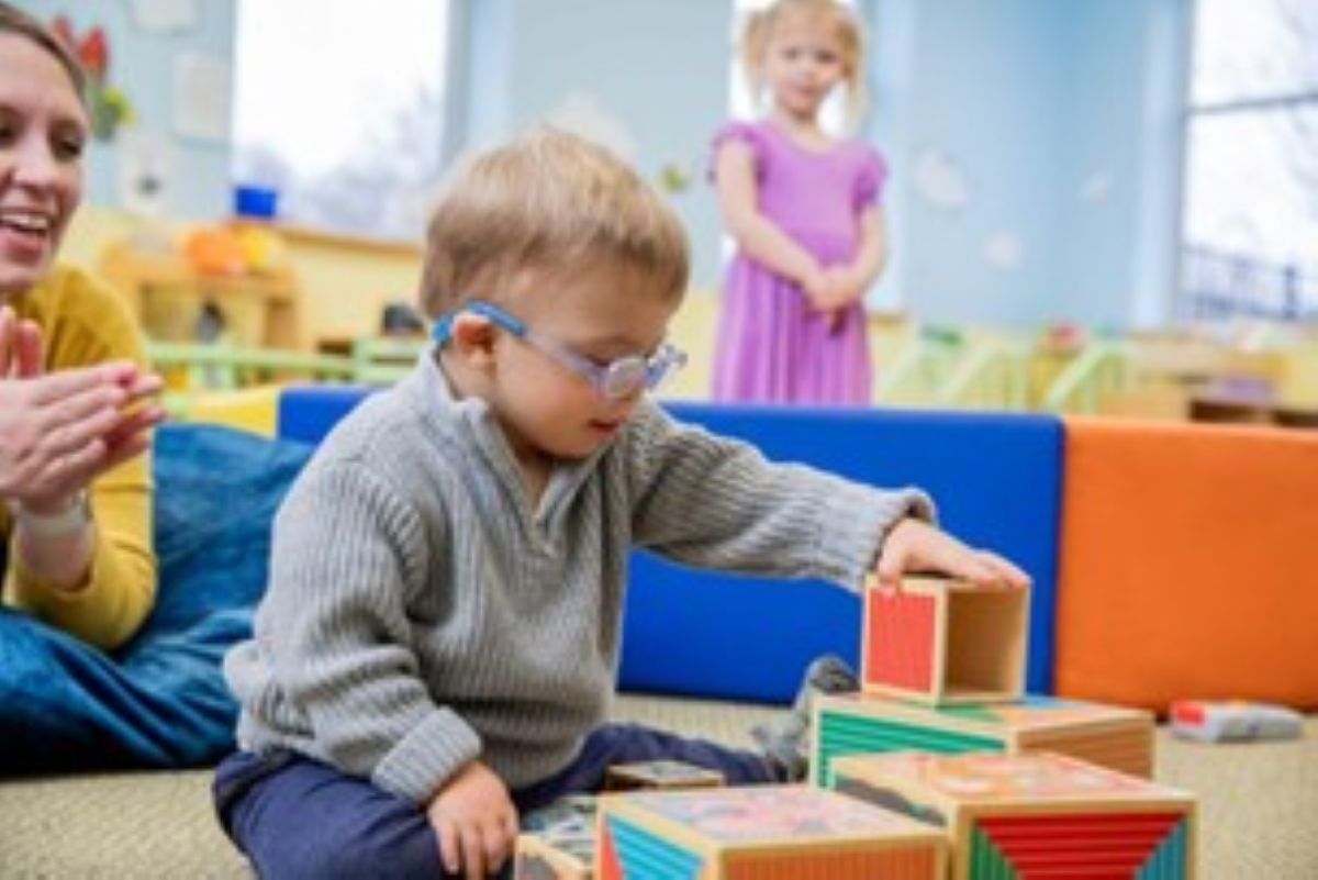Toddler Boy Stacks Blocks in Preschool Classroom